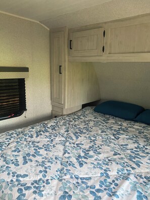 A bedroom with a bed, a window with blinds, and a built-in wardrobe. - Cozy  1-bedroom recreational vehicle with views close to Kalispell. (Kalispell)