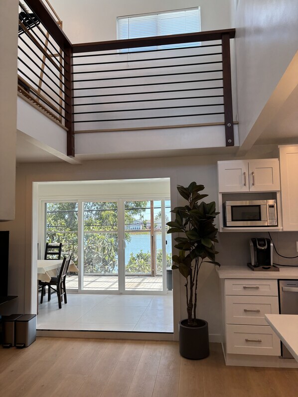 A modern kitchen with a microwave, coffee maker, and a potted plant.