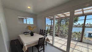 Een eetgedeelte met een tafel, stoelen en een bloevas.