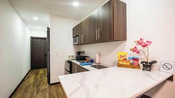 Cafetera o tetera, frigorífico, microondas y placa de cocina