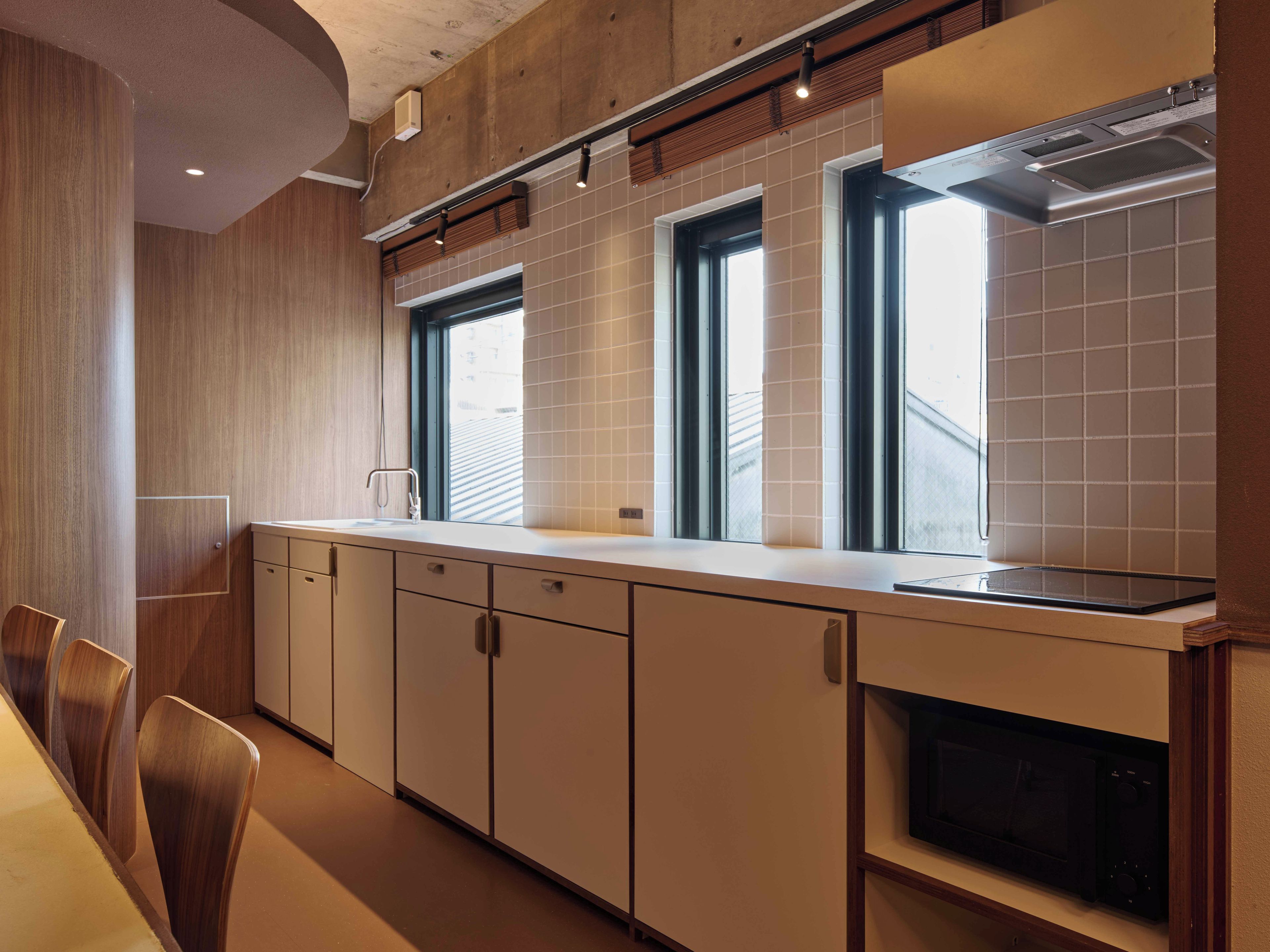 A modern kitchen with a built-in oven, a microwave, and a window above the sink.
