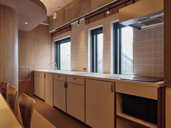 Una cocina moderna con horno empotrado, microondas y ventana sobre el fregadero.
