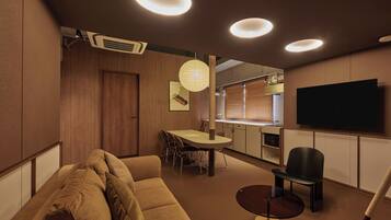 Una sala de estar moderna con un sofá, una mesa de comedor y un televisor montado en la pared.