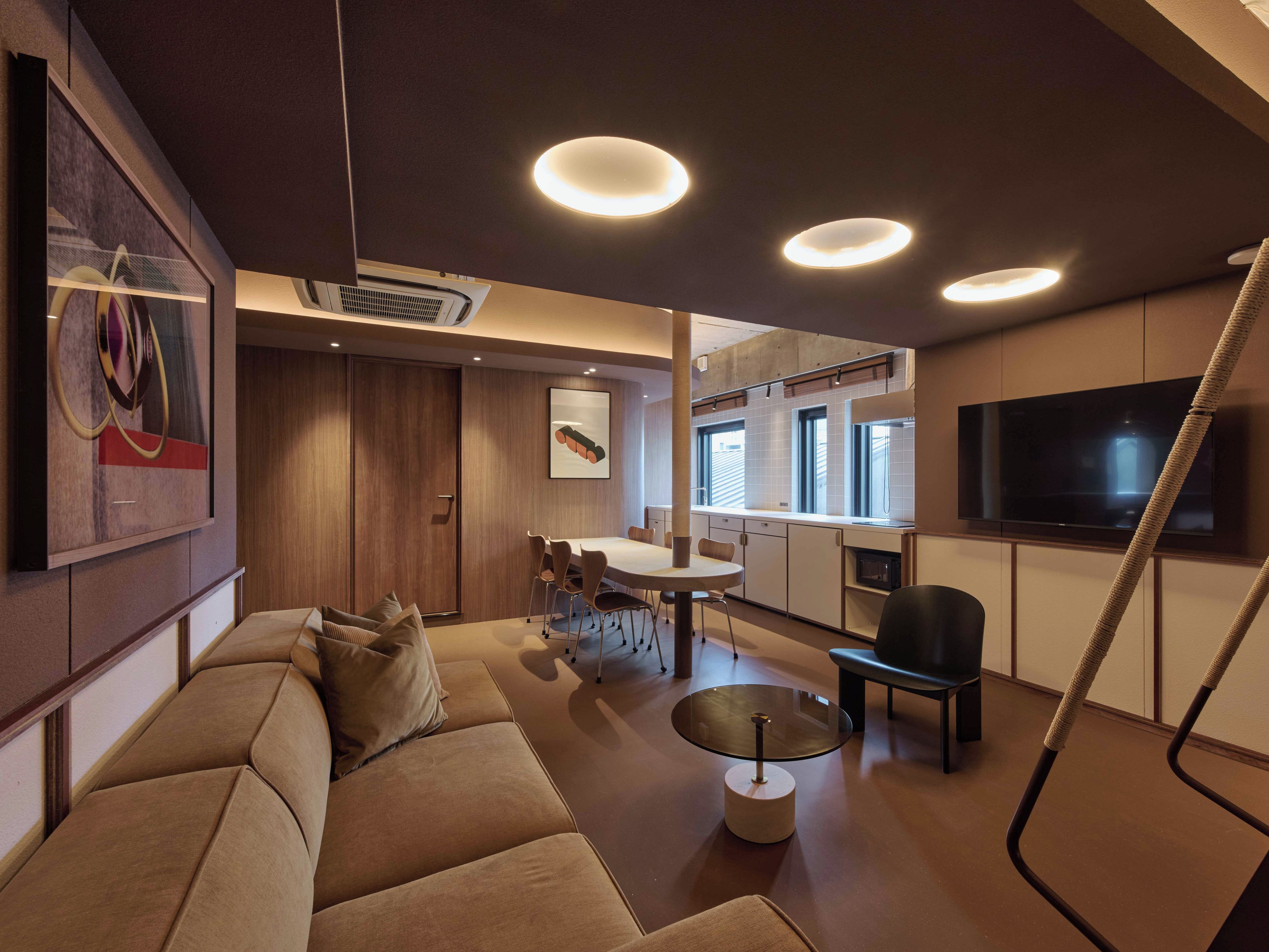 Una sala de estar moderna con un sofá, una mesa de centro de vidrio y un comedor con sillas.