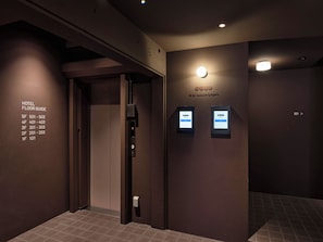 Un ascensor con un panel de botones en la pared, que indica los pisos del hotel y sus números.