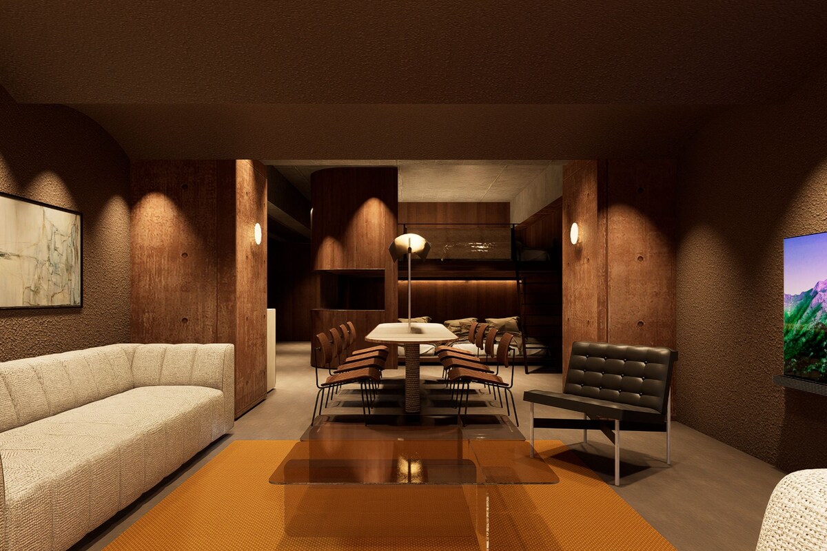 Un interior moderno con sofá, mesa de comedor, sillas y televisor.