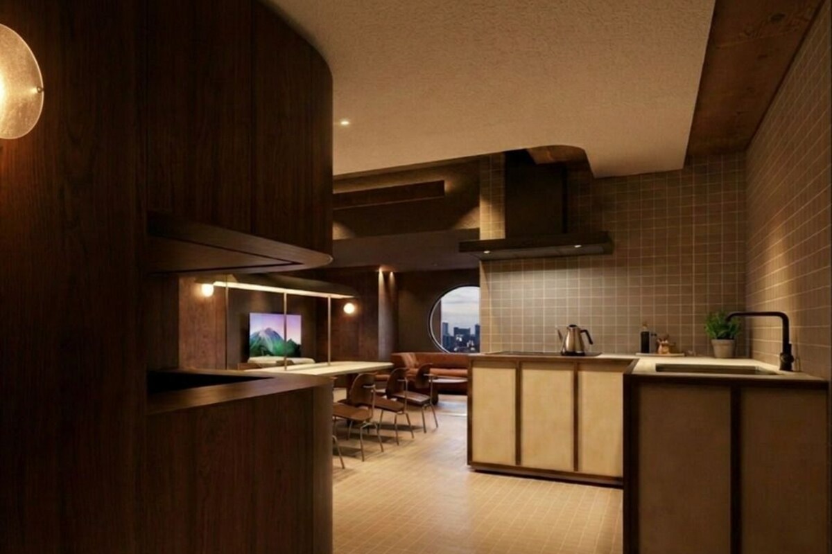 Une cuisine moderne dotée d’un îlot central, d’appareils électroménagers intégrés et offrant une vue dégagée grâce à une grande fenêtre.