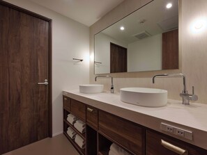Une salle de bain moderne avec un double vasque, un grand miroir et des meubles en bois.