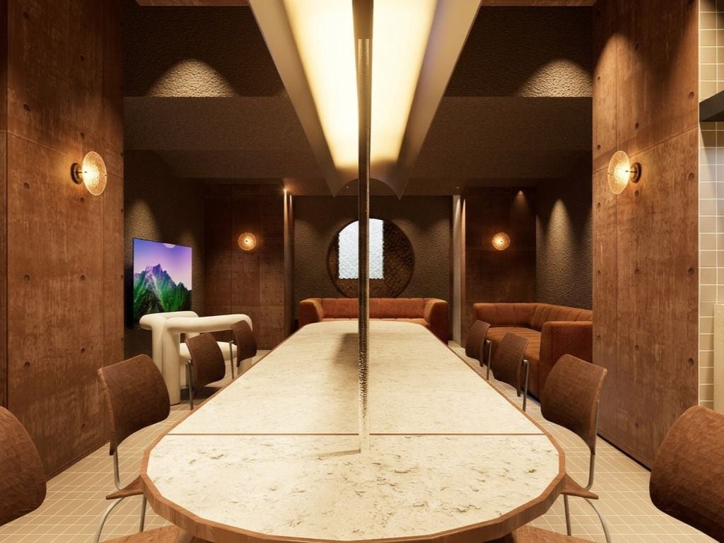 A conference room with a long table, chairs, and a TV screen.