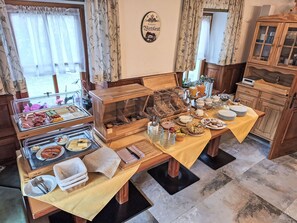 Um buffet de café da manhã com diversas opções de comida e um espaço para café.