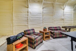 A room with a pool table, two plaid sofas, a small wooden table with a bag and a remote control, and a wall with a textured finish. - Private Hot Tub & 2-Story Sundeck! Lakefront Log Cabin on 1 acre in Onalaska! (Onalaska)