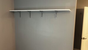 A wall with a white shelf and four hooks. - Elevated three master suites with jet tub, large kitchen, full of amenities (Camden)