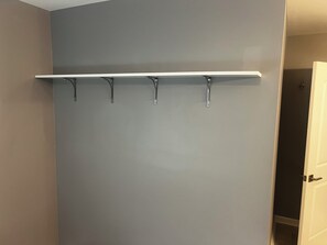 A wall with a white shelf and four hooks. - Elevated three master suites with jet tub, large kitchen, full of amenities (Camden)