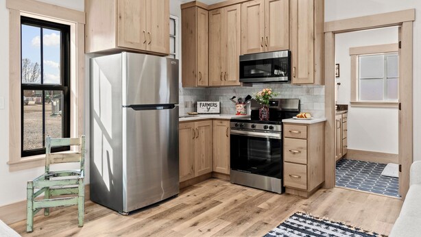 Una cocina moderna con armarios de madera, electrodomésticos de acero inoxidable y una ventana de estilo rústico.