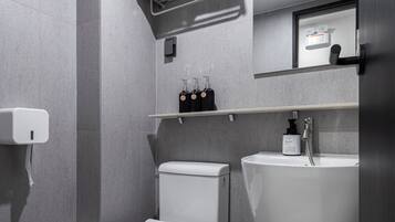 Un baño moderno con inodoro, lavamanos y toallero.