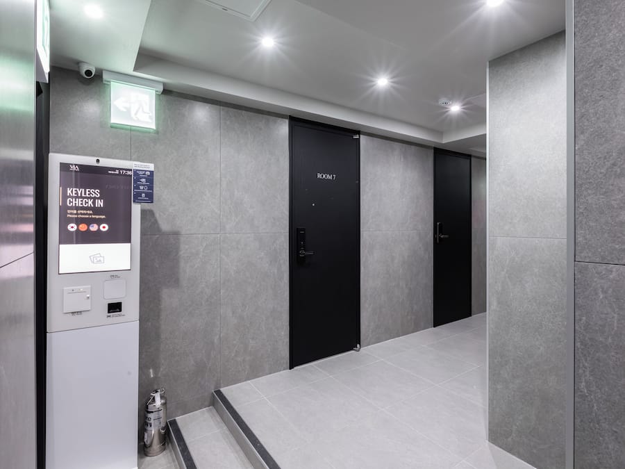 Um elevador moderno com sistema de entrada sem chave, visor digital e placa indicando o número do quarto.