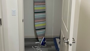 A hallway with a closet containing a striped surfboard and a blue bag. - 3 BdR Suite in Calgary - Enjoy Rockies, Banff, Lake Louise, Dinosaur museum (Calgary)