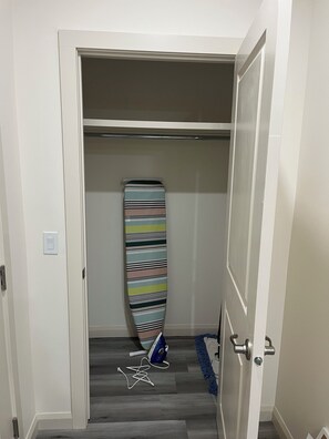 Ein Flur mit einem Schrank, der einen gestreiften Surfbrett und eine blaue Tasche beherbergt.