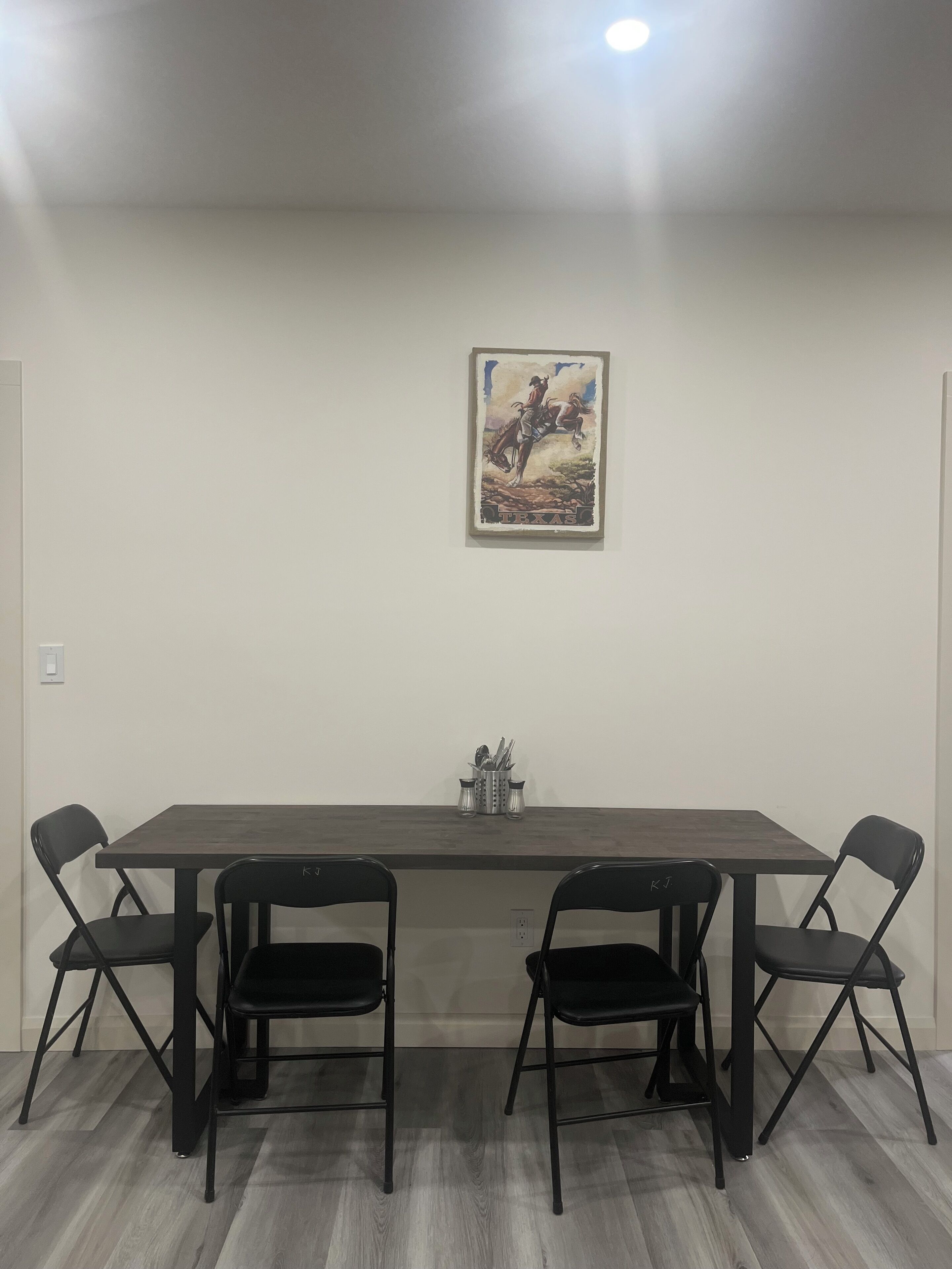 Une salle de conférence avec une longue table, quatre chaises et un tableau représentant un cow-boy à cheval.