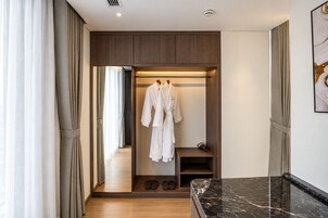 A hotel room with a walk-in closet, a marble countertop, and a pair of shoes on the floor.