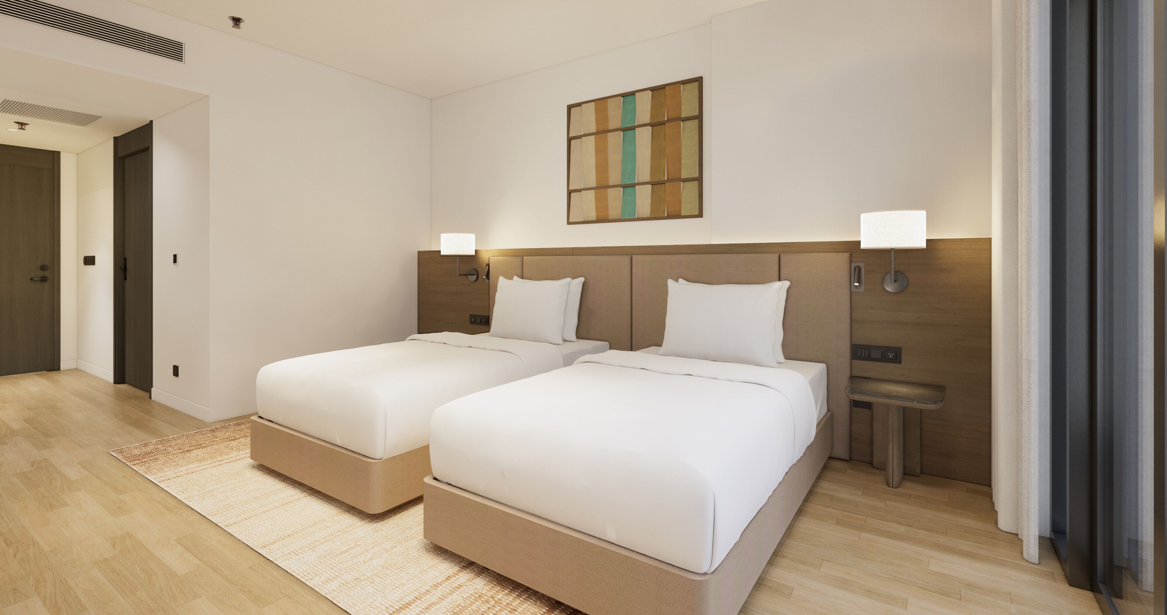 A hotel room with two beds, a wooden headboard, a painting on the wall, and a small table.