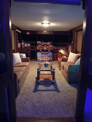 A cozy living room with a central coffee table, two sofas, and a decorative wheel.
