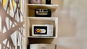 Eine Küche mit einem Edelstahl-Kühlschrank, einer Mikrowelle und einem Toaster auf einer Ablagefläche.