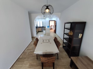 A dining area with a table, chairs, and a hanging light fixture. - Beachfront apartment with a terrace and ocean view (Marina Saidia)