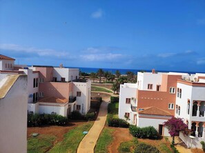 Ein Wohngebiet mit Gebäuden, einem Weg und Blick auf das Meer.