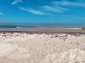 Ein Strand mit blauem Himmel und ruhiger See.