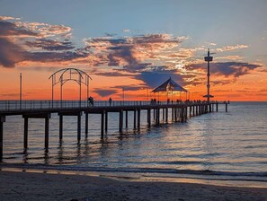 Eine Stegkonstruktion, die sich ins Wasser erstreckt, mit einem Pavillon und einem Leuchtturm am Ende.