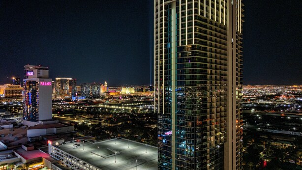 A high-rise building with a modern glass facade and a prominent vertical light strip. - Cozy studio with AC in serene Las Vegas location (Las Vegas)