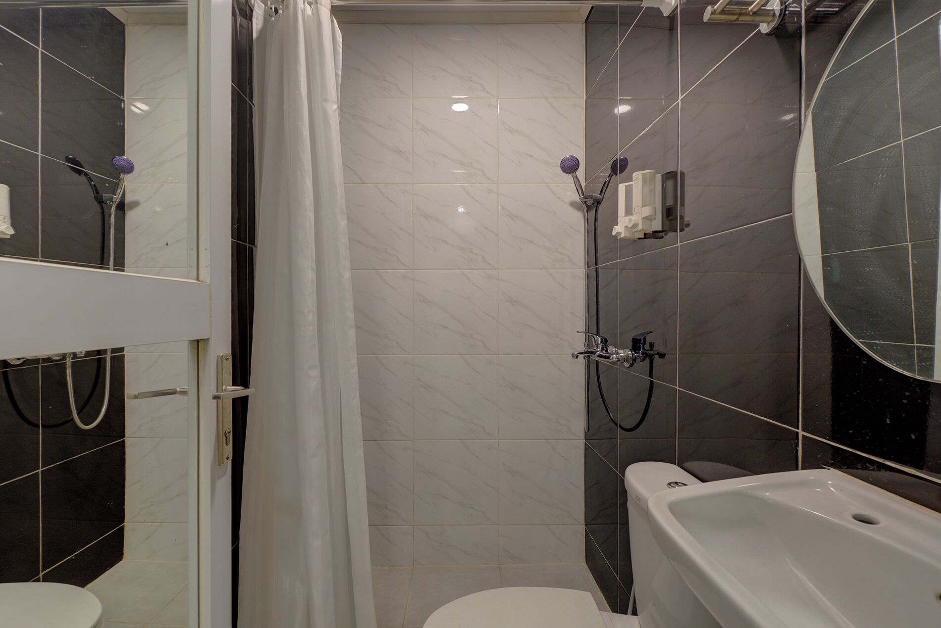 A bathroom with a shower, toilet, and sink.