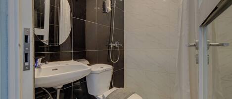 A modern bathroom with a shower, toilet, and sink.