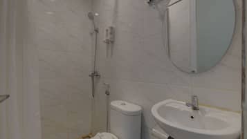Un baño con inodoro, lavamanos y ducha.