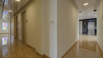 A clean, modern hallway with a polished floor, a door, and an elevator.