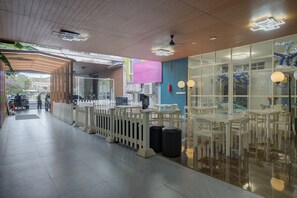 A restaurant with outdoor seating, a wooden ceiling, and a view of the street. - Hotel Bunga-Bunga By ARBA (Jakarta)