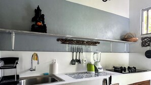 Uma cozinha com pia, fogão e diversos utensílios.