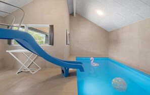 Ein Swimmingpool mit einer blauen Rutsche und einem rosa Flamingo-Schwimmpflege.