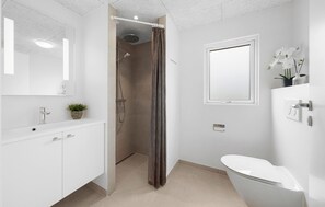 Une salle de bain moderne équipée d’une douche, de toilettes et d’un lavabo.