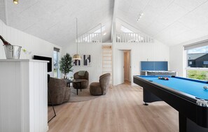 A modern indoor pool area with a pool table, seating, and a view of the outdoors. - Amazing home in Bogense with sauna (Bogense)