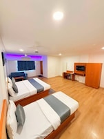 Une chambre d’hôtel avec deux lits, un bureau, une télévision et une armoire.