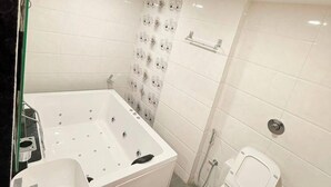 A bathroom with a bathtub, a toilet, and a sink. - Hotel Royal Elite (Vapi)