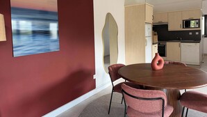 A modern kitchen with a microwave, oven, and cabinets. - T2 appartement 1 chambre en RDJ avec terrasse (Anglet)