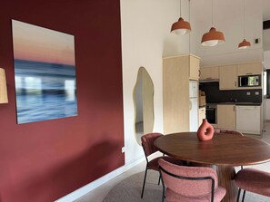 A modern kitchen with a microwave, oven, and cabinets. - T2 appartement 1 chambre en RDJ avec terrasse (Anglet)