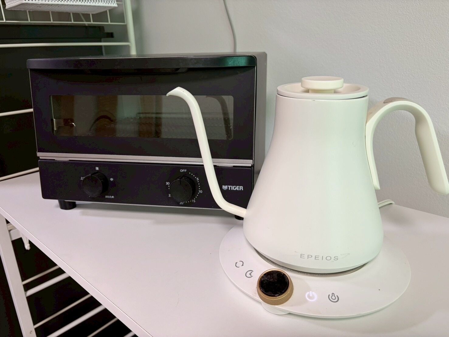 A kitchen with a microwave, a white electric kettle, and a toaster.