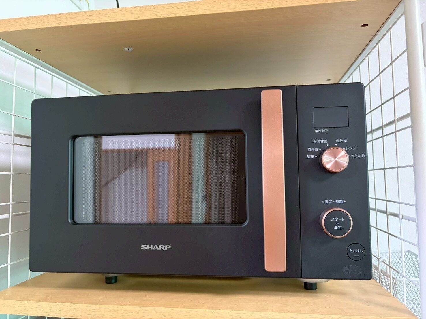 A black Sharp microwave oven with a digital display and control buttons on the right side.