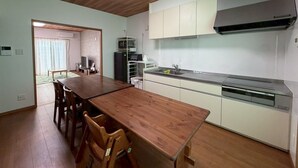 Une cuisine de taille réduite avec un coin repas, un plafond en bois et une grande fenêtre.