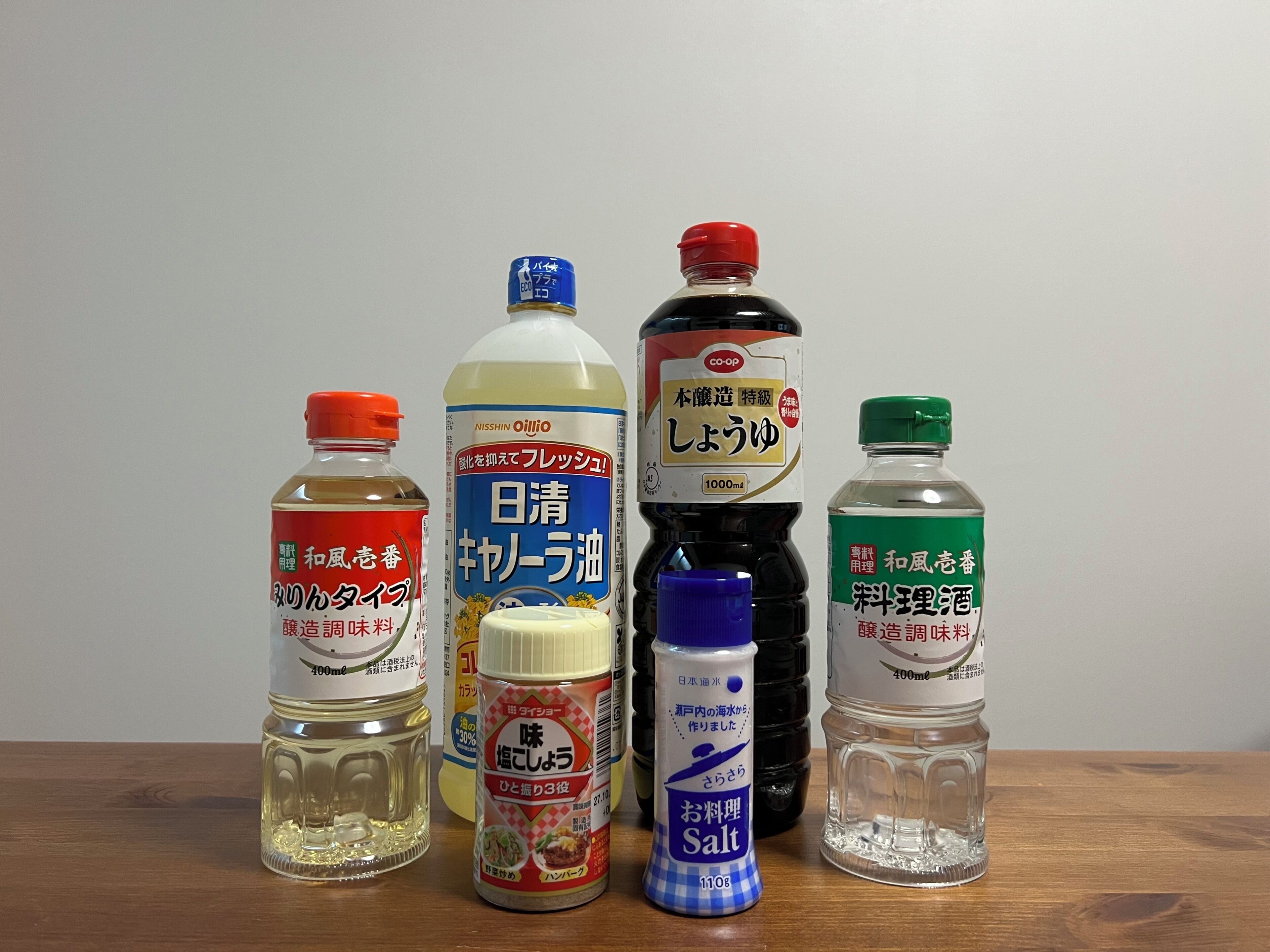 A variety of condiment bottles on a wooden surface.
