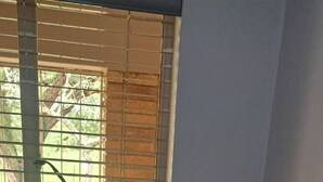 A white front-loading washer and dryer in a corner with a window above.
